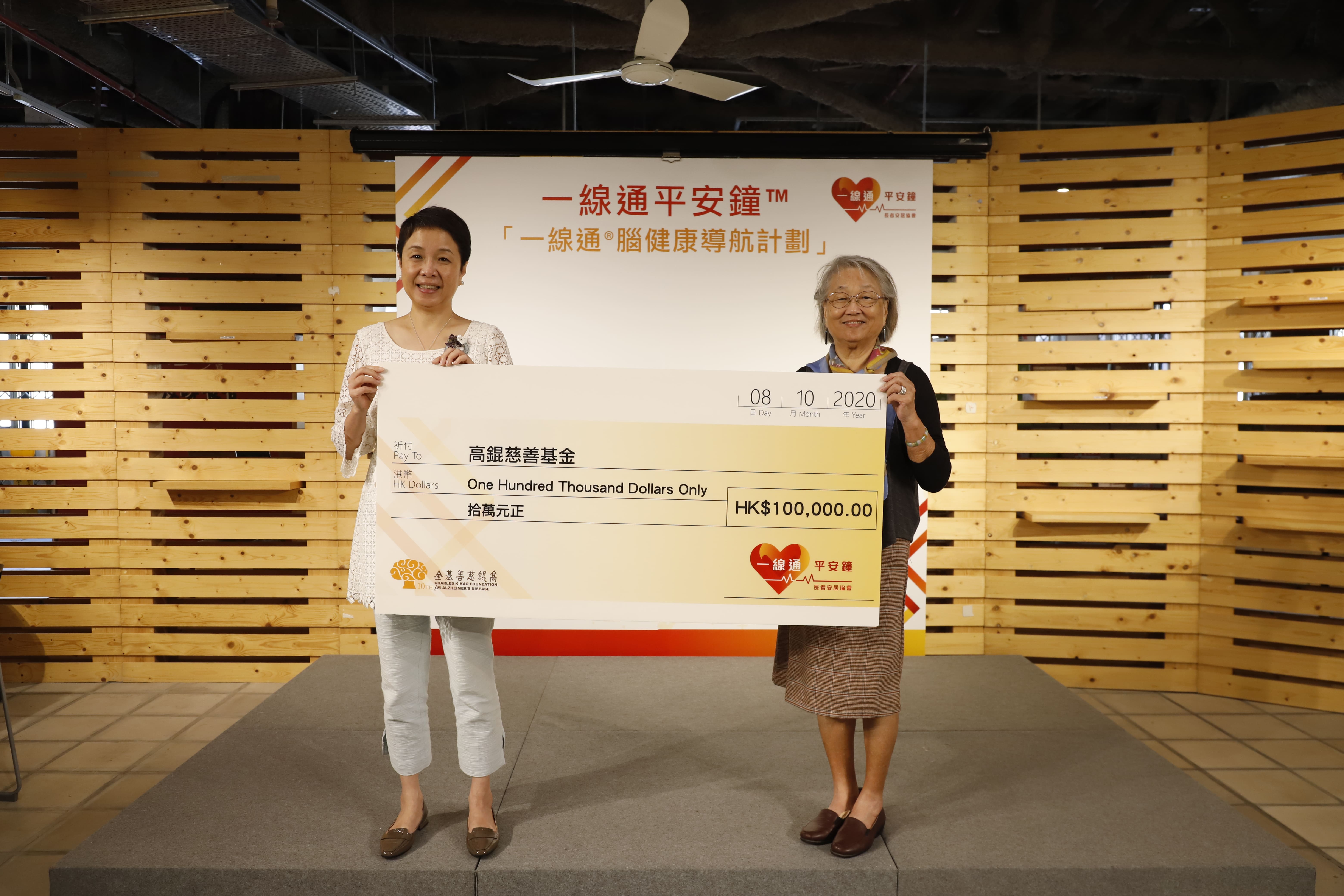 圖片二: 長者安居協會捐出港幣十萬元支持高錕慈善基金月餅義賣活動，協會行政總裁王虹虹(王蓉)(左)主持支票移交儀式，由高錕慈善基金主席高黃美芸(右)接受，高黃美芸女士表示基金全力支持「一線通®腦健康導航計劃」，希望計劃能惠及更多有需要的人。